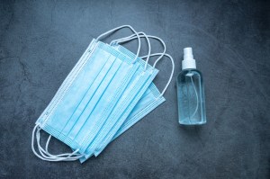 Face masks next to a bottle of hand sanitiser.
