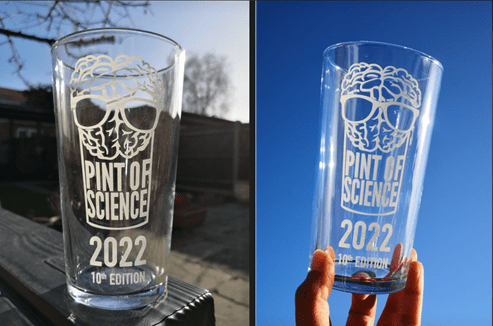 2 pictures side-by-side of a branded Pint of Science pint glass. The one on the left is resting on a wooden table against a backdrop of trees in the distance. The one on the right is being held by someone against a blue background, which looks like the sky.